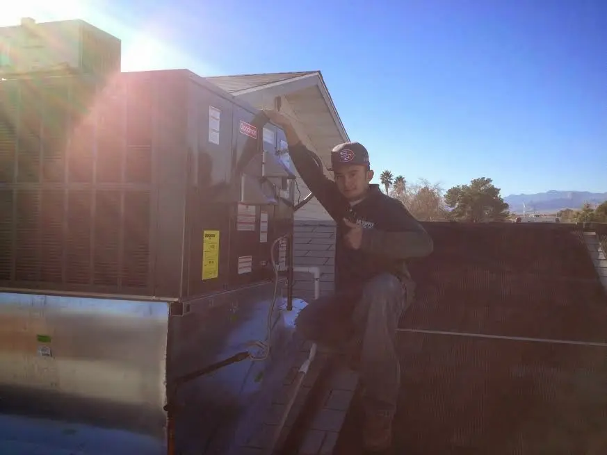 HVAC technician performing Heat Pump Repair on a rooftop unit in Trussville
